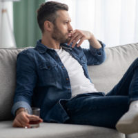 a sad man sitting on the couch